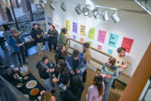 Vanderbilt students in Jana Harper's class, along with guests and artists, gather to view the zine and poster exhibit.